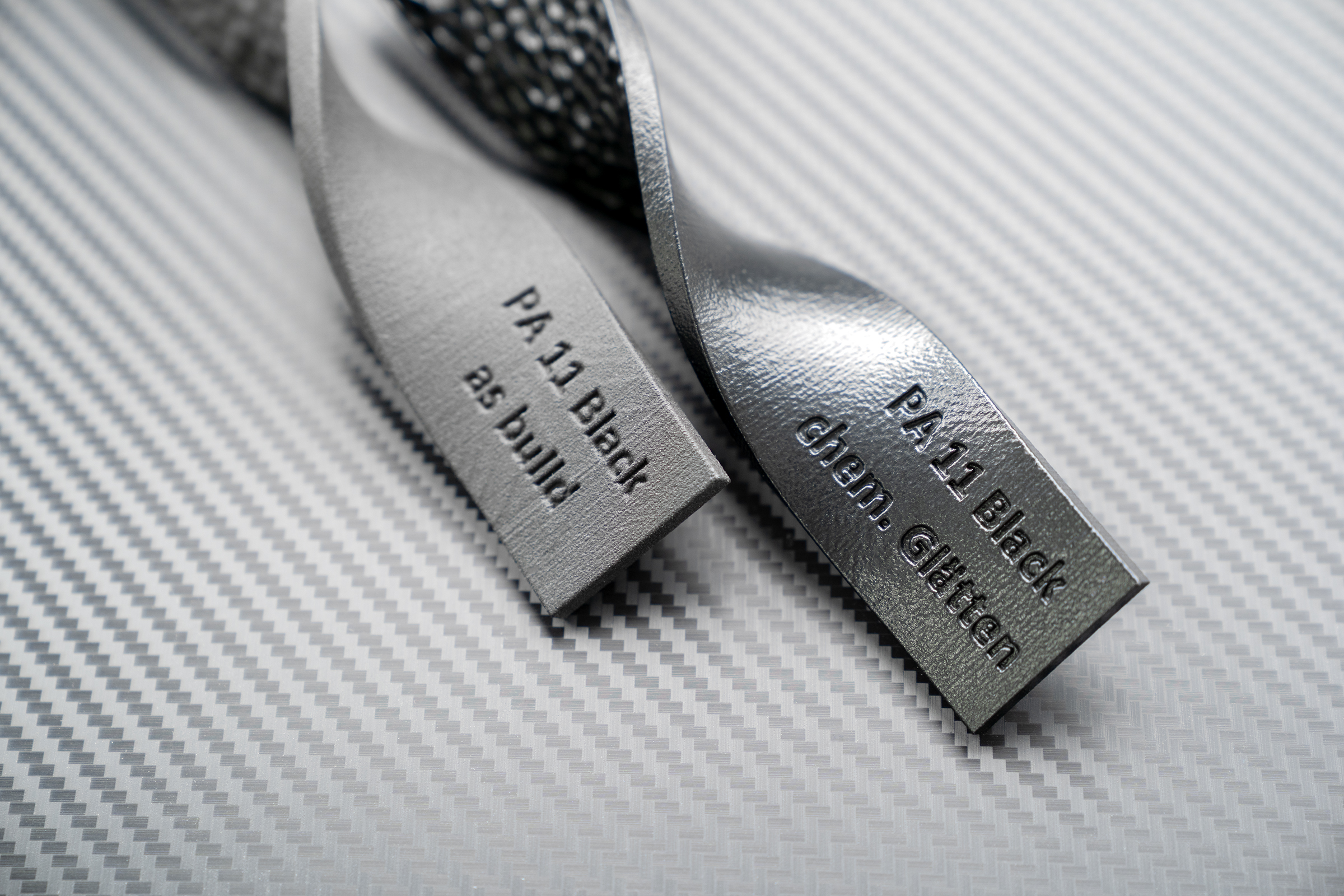 Two black plastic components, one smoothed, one untreated.