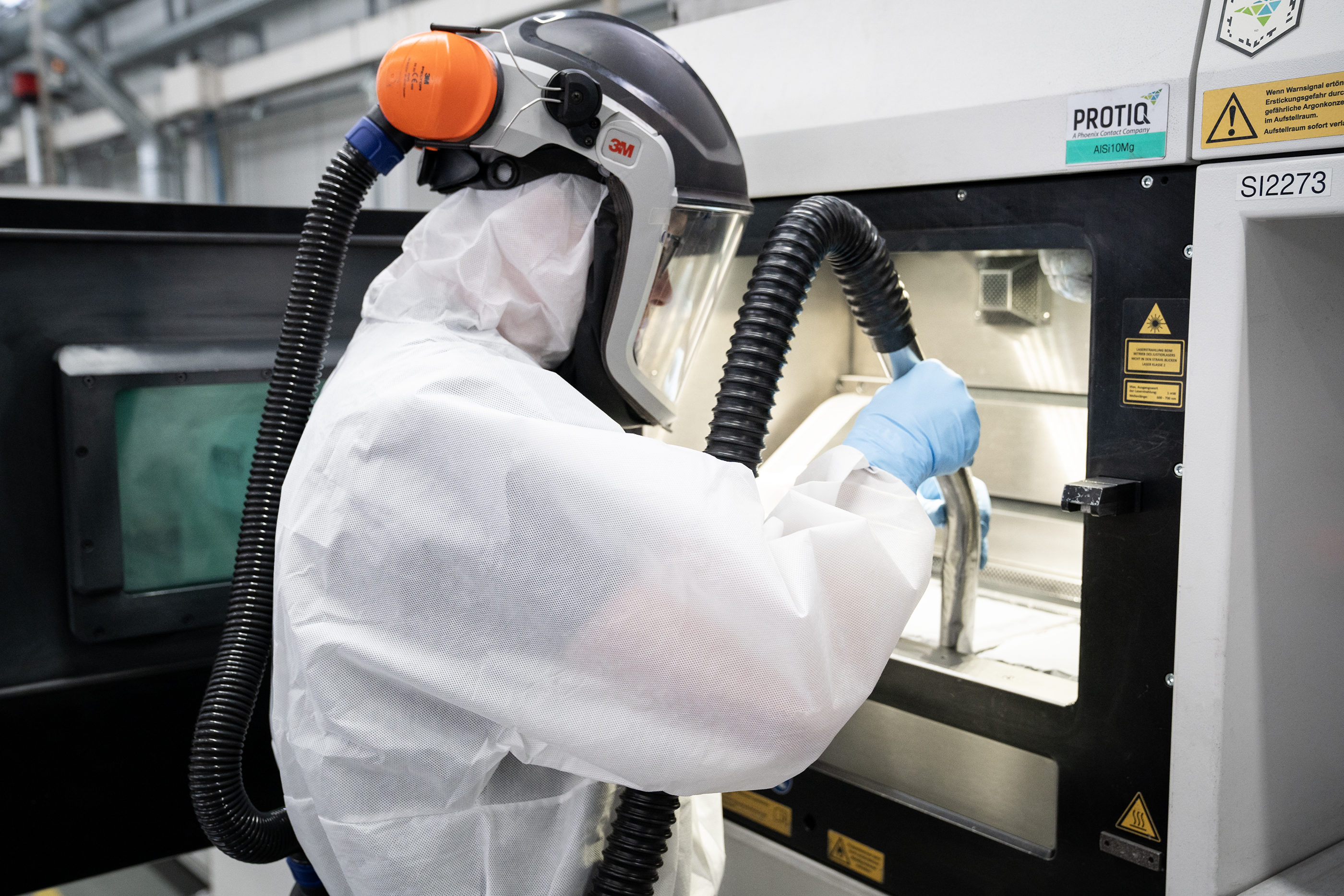 Mitarbeiter im Metall 3D-Druck Bereich beim Auspacken eines 3D-Druck-Jobs